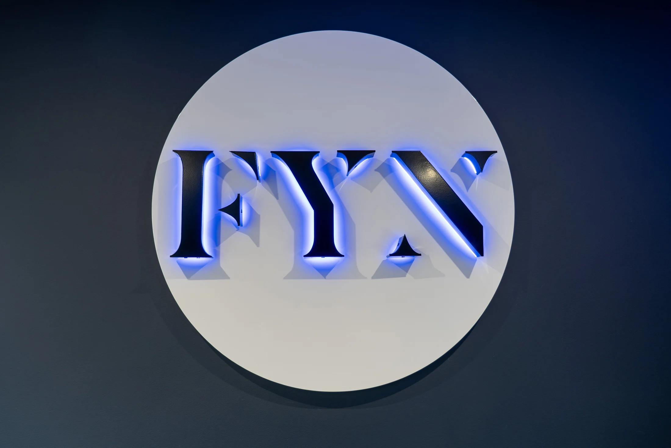 Illuminated FYN lettering in a circular wall sign